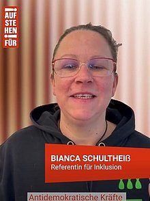 Frau schaut in Kamera bei einem Vortrag