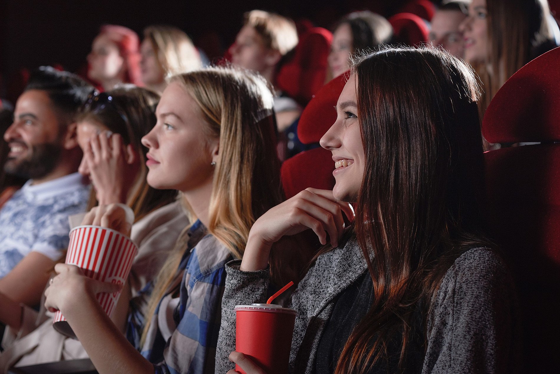 zwei Mädchen mit Popcorn in der Hand schauen einen Film