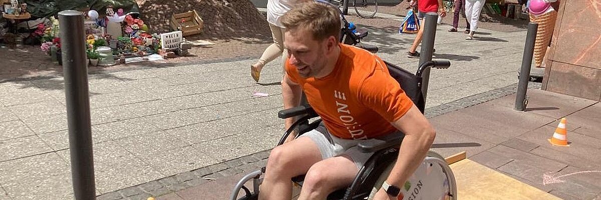 ein Mann fährt in einem Rollstuhl über eine Wippe