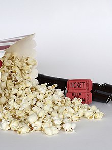 umgefallene Popcorntüte, Filmstreifen und Ticket