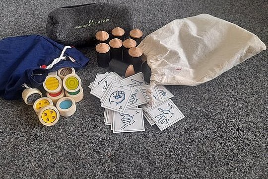 verschiedene Spiele wie Hörmemory, Fingeralphabet usw. liegen auf dem Boden